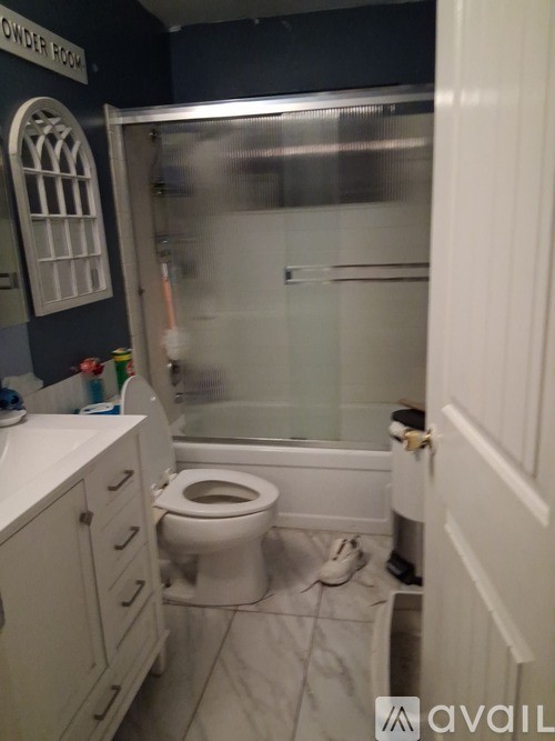 A bathroom with a toilet, sink, and a shower stall.