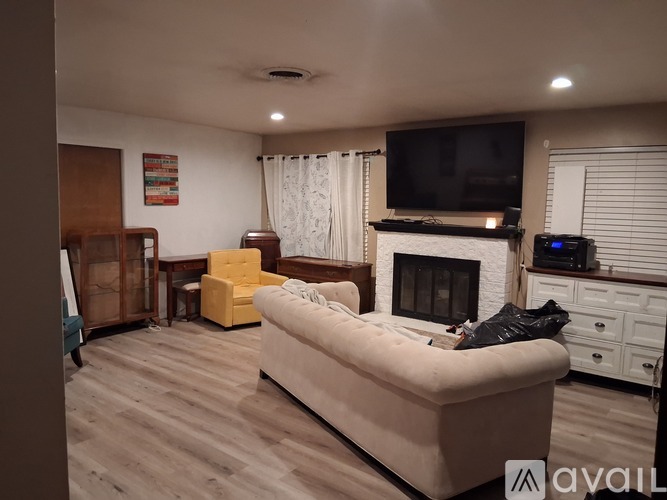 A living room with a couch, a television, and a fireplace.