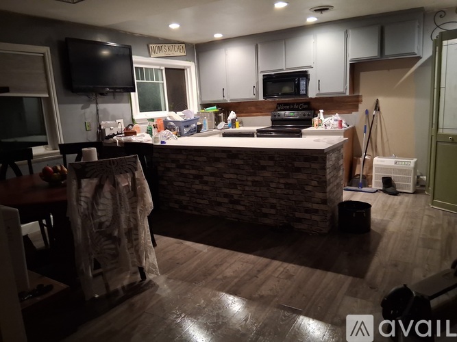 A kitchen with a stone counter and wooden floors.