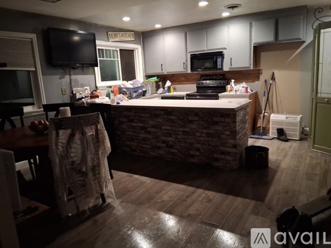 A kitchen with a stone counter and wooden floors.