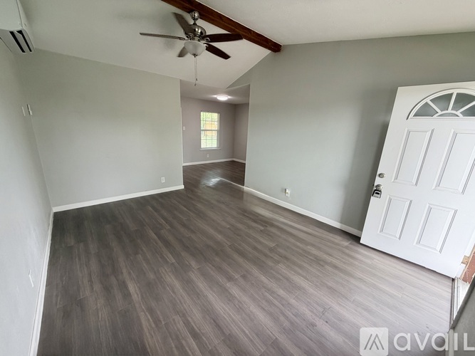 A room with a white door and a ceiling fan.