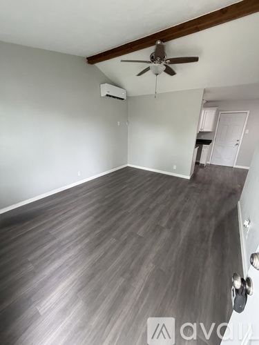 A room with a ceiling fan and a wall-mounted air conditioner.