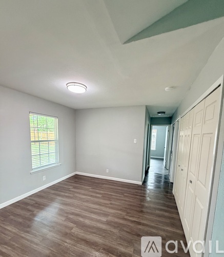 A room with a window and wooden flooring.