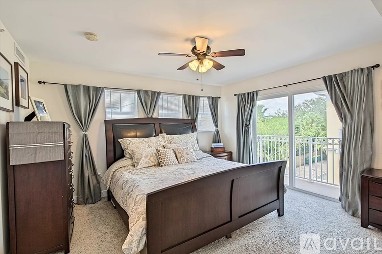 A bedroom with a large bed and a ceiling fan.