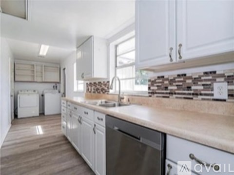 A kitchen with white cabinets and a wooden counter.