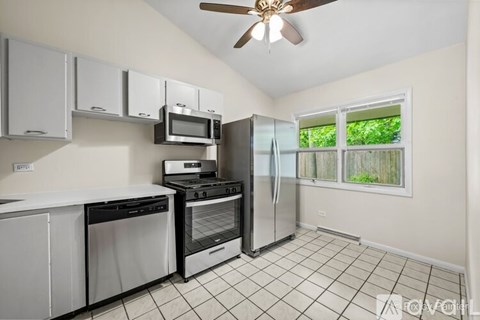 A kitchen with white cabinets and black appliances.