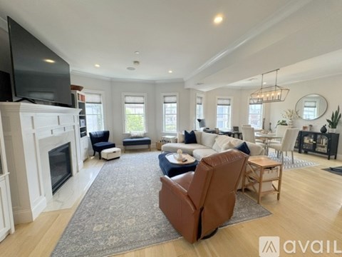A living room with a fireplace and a television on the wall.