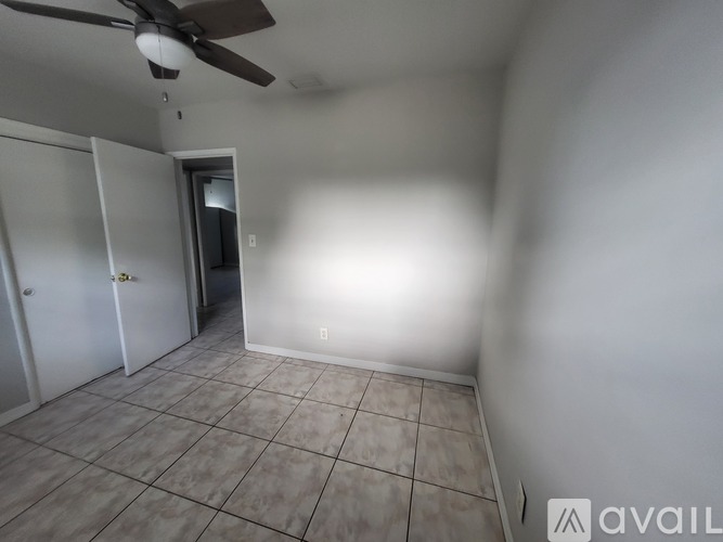 A room with a ceiling fan and tile flooring.