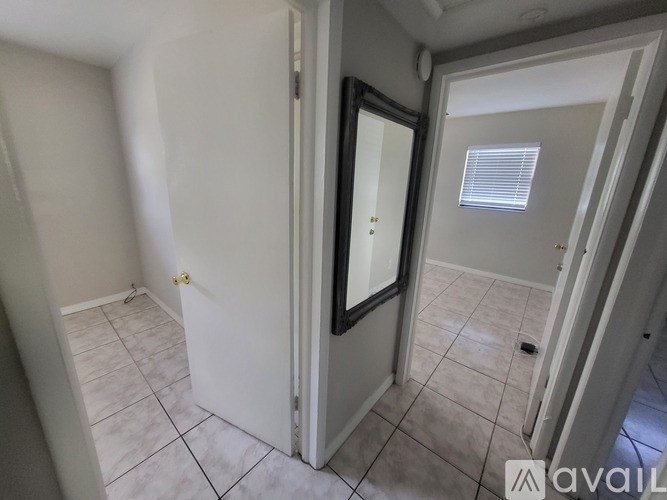 A room with a door and a mirror on the wall.
