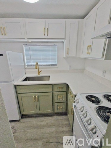 A kitchen with white cabinets and a green island.