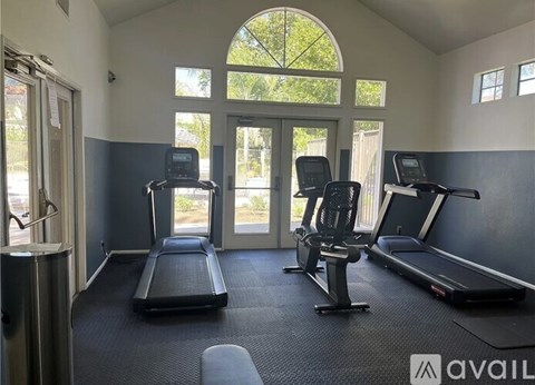 A gym with treadmills, elliptical machines, and a stationary bike.