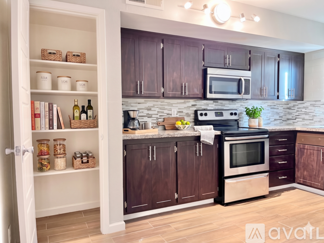 A kitchen with brown cabinets and a white door.