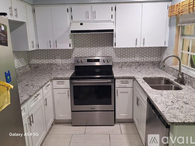 A kitchen with white cabinets and a black stove top oven.