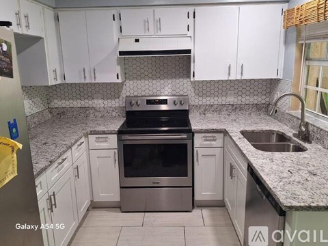 A kitchen with white cabinets and a black stove top oven.