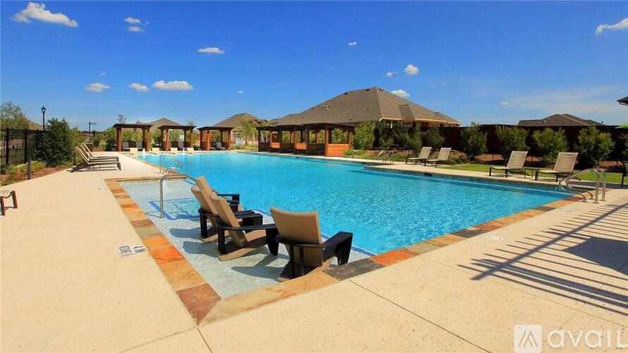 A large outdoor swimming pool surrounded by sun loungers and umbrellas.