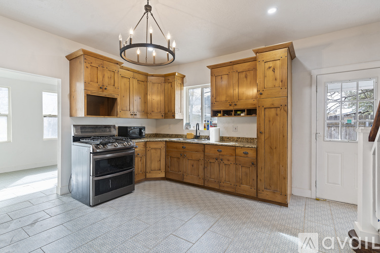 A large kitchen with wooden cabinets and a tiled floor.