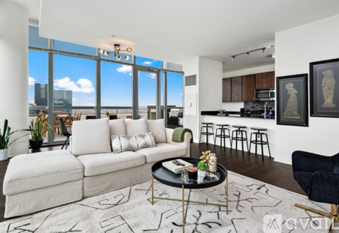 A living room with a white couch and a coffee table in front of a large window.