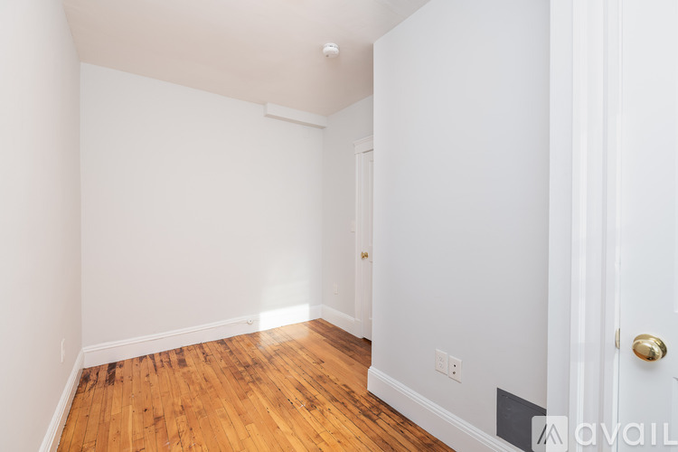 A room with a wooden floor and white walls.