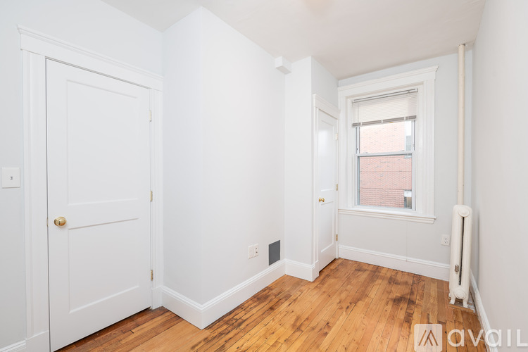 A white door is on the left and a window with a white frame is on the right.