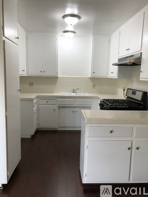 A kitchen with white cabinets and a counter.