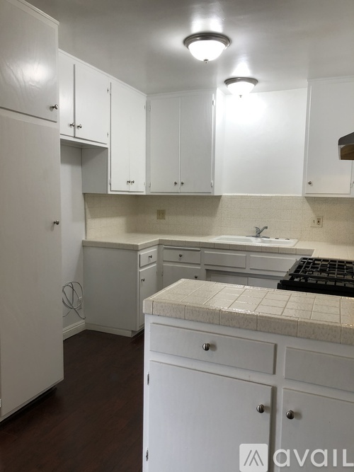 A kitchen with white cabinets and a tiled backsplash.