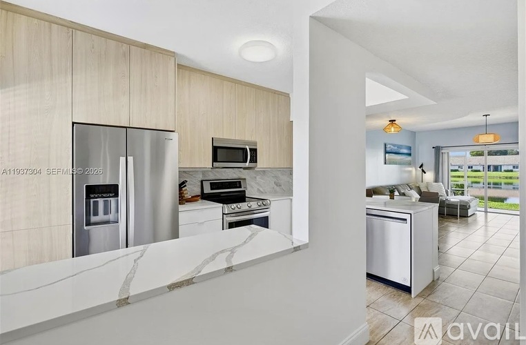 A modern kitchen with a refrigerator, microwave, oven, and dishwasher.