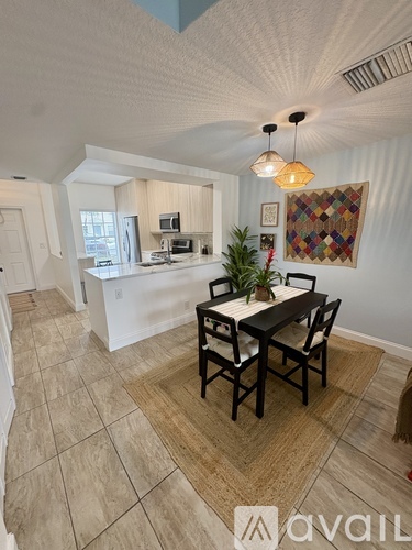 A dining room with a table and chairs in the middle of the room.