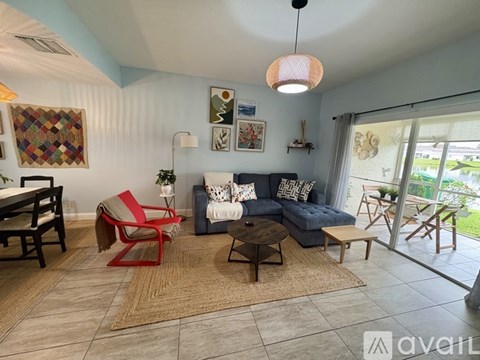 A living room with a red chair and a grey couch.