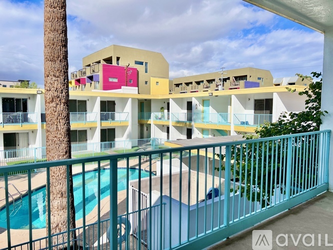 A pool is surrounded by a fence in front of a building.