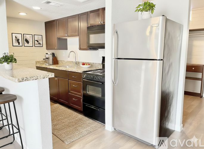 A kitchen with a white refrigerator and brown cabinets.