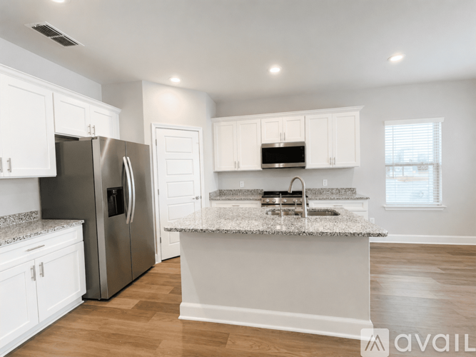 A kitchen with white cabinets and a granite countertop.
