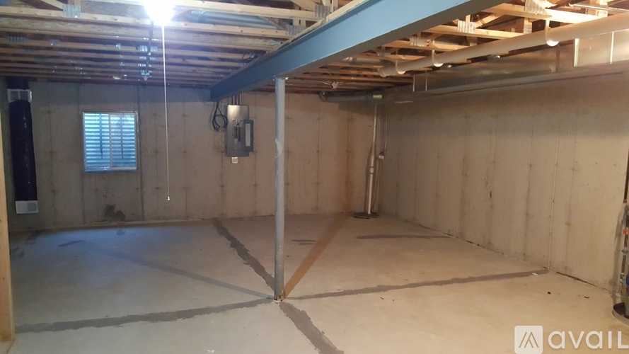 A spacious room with wooden walls and a concrete floor.