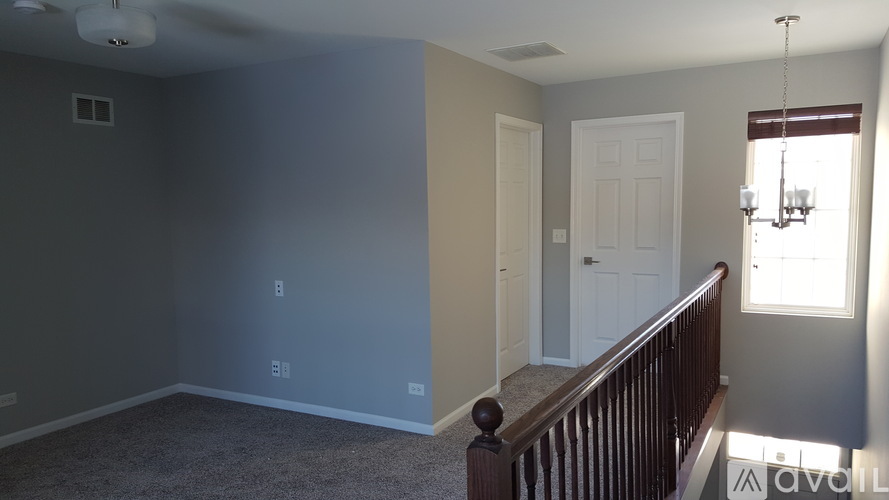 A room with a ceiling fan and a light switch.