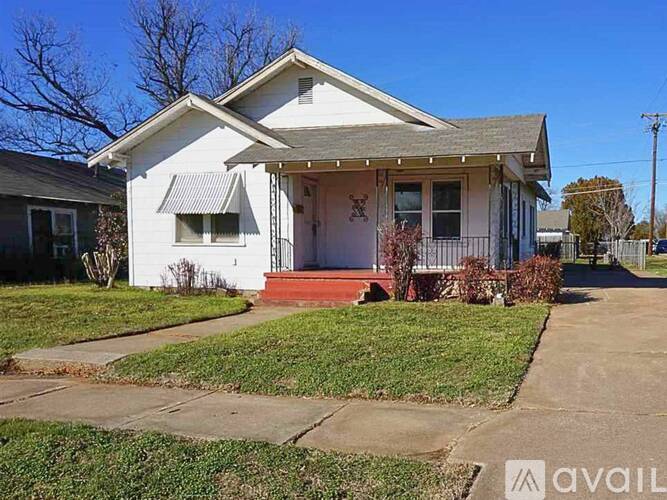 A white house with a red door and a small porch.