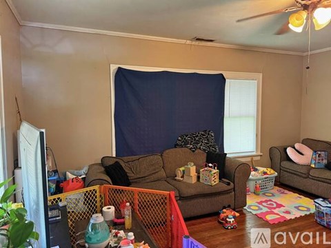 A living room with a brown couch and a blue curtain.
