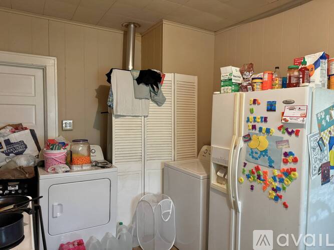 A kitchen with a refrigerator covered in magnets and papers.