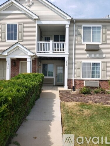 A two-story house with a balcony on the second floor.