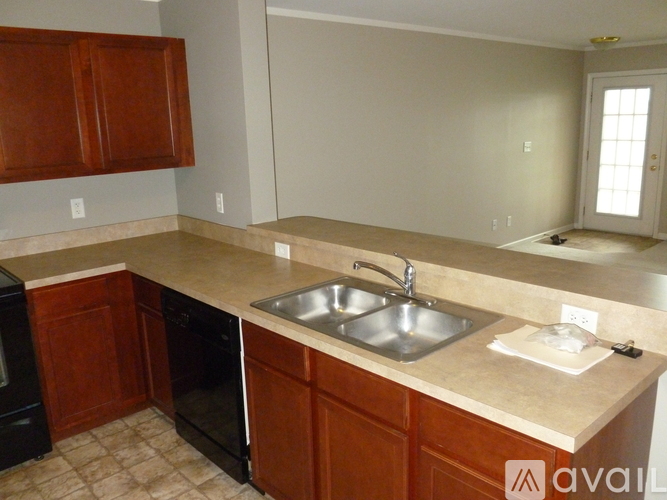 A kitchen with brown cabinets and a beige countertop.