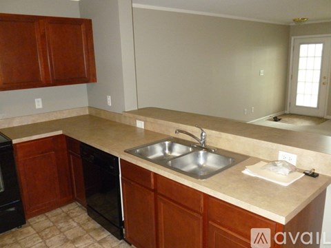 A kitchen with brown cabinets and a beige countertop.