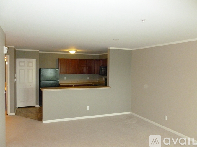 A kitchen area with a refrigerator, cabinets, and a countertop.