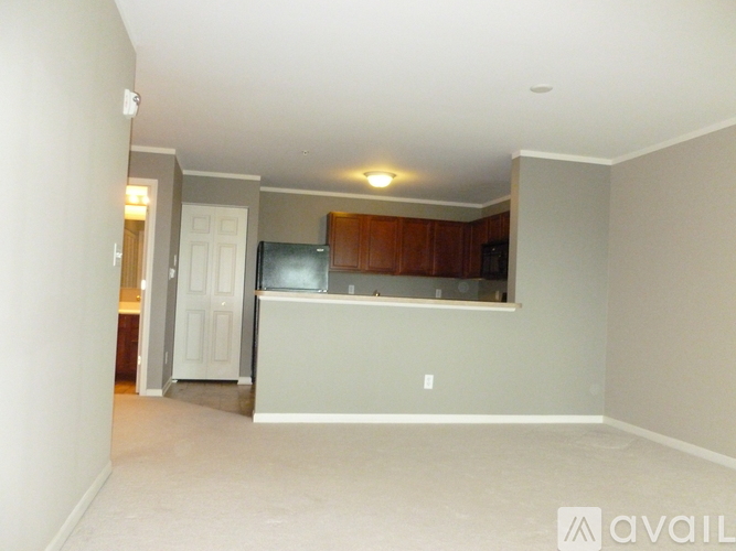 A living room with a flat screen TV and a refrigerator.