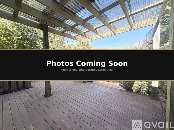 A wooden deck with a roof and a sign that says "Photos Coming Soon".