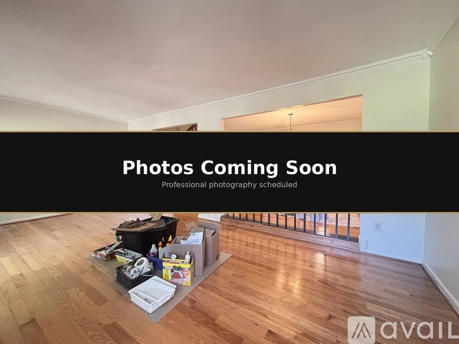 A room with a wooden floor and a sign that says "Photos Coming Soon" and "Professional photography scheduled".