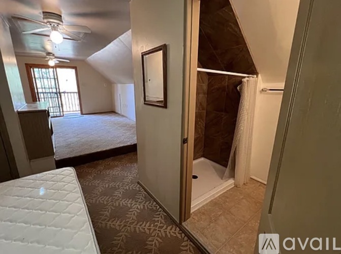 A bedroom with a bed, dresser, and mirror.