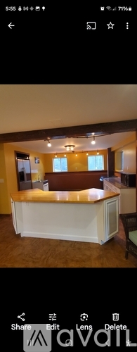 A white bar counter in a room with wooden flooring.