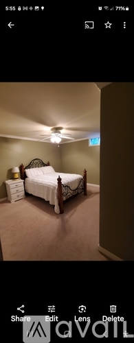 A bedroom with a bed, nightstand, and lamp.