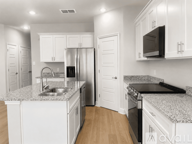 A kitchen with white cabinets and a granite countertop.