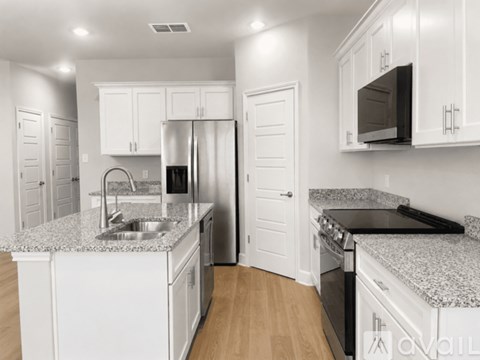 A kitchen with white cabinets and a granite countertop.
