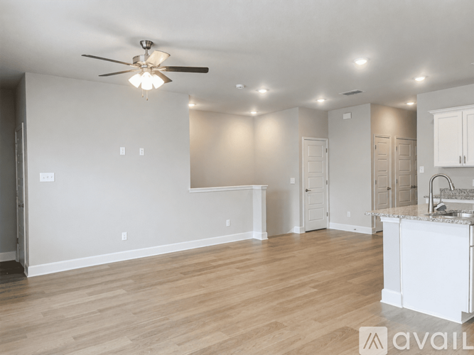A spacious room with a ceiling fan and wooden flooring.