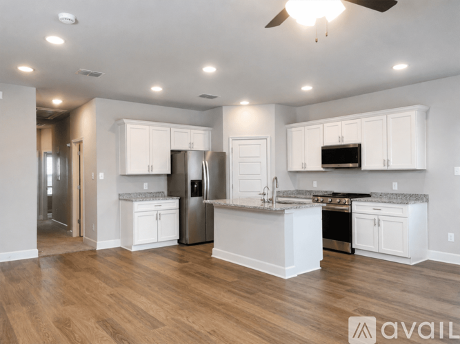 A spacious kitchen with white cabinets and a center island.